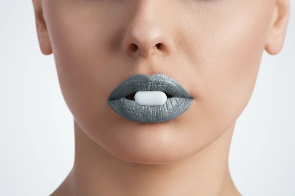 Pill between female lips — Stock Photo, Image