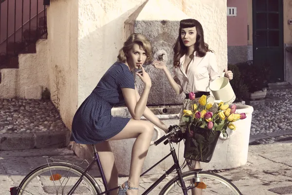 Casal de meninas da moda com bicicleta — Fotografia de Stock