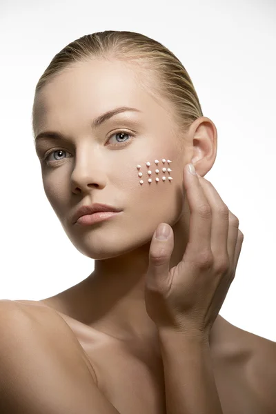 Mujer aplicando cosméticos en el rostro — Foto de Stock