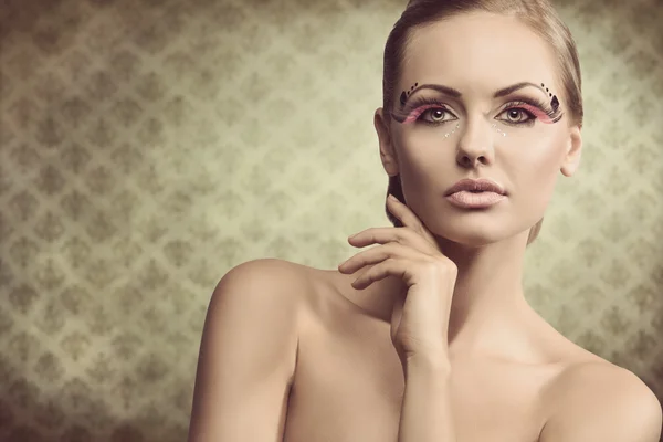 Mädchen mit kreativem gefiederten Make-up — Stockfoto