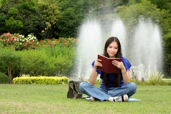 公園で本を読んでかなり若い女性 ロイヤリティフリーのストック写真