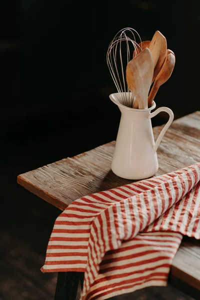 Foto verticale di utensili da cucina vintage in vaso di ceramica bianca su tavolo di legno. Arredare la cucina di casa. Utensili da cucina per cucinare. Articoli per la casa — Foto Stock