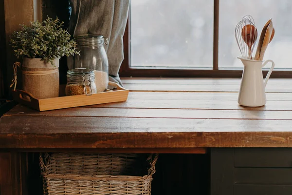 Utensilios de cocina en recipiente blanco sobre mesa de madera cerca de la ventana. Decoración de la cocina del hogar. Utensilios de cocina. Hora de cocinar. Cubertería en la habitación. —  Fotos de Stock