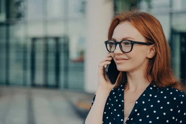 Redhead businwoman 은 전화 통화를 가지고 있으며 현대적 인 휴대폰 기기를 사용 합니다. — 스톡 사진
