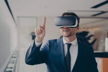 Üç boyutlu gözlüklü, gülen sakallı iş adamı işindeki artırılmış gerçeği kullanıyor.