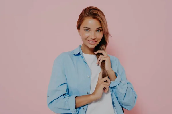 Jovem mulher morena atraente com maquiagem natural tocando suavemente seu cabelo — Fotografia de Stock