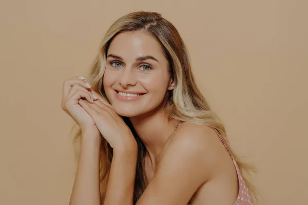 Pretty young blonde woman in dress looking with beaming smile at camera — Stock Photo, Image