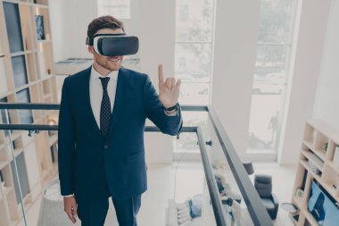 Resmi siyah takım elbiseli çekici sakallı iş adamı kablosuz VR kulaklık takıyor.