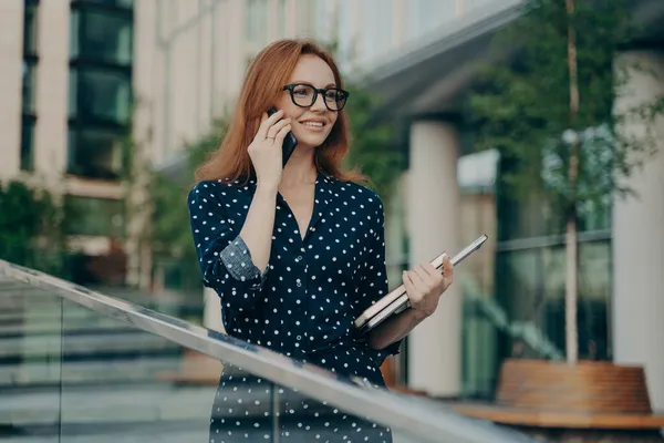 빨간 머리를 가진 행복 한 성인 여성 이 스마트폰으로 컨설팅을 합니다. — 스톡 사진