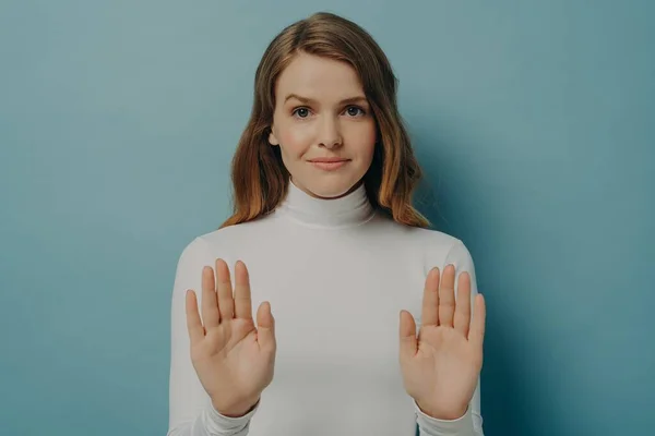 Attraktiv ung fokuserad kvinna visar stopp gest, säger nej, isolerade över blå studio bakgrund — Stockfoto