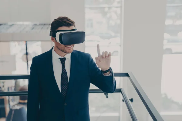 Niesamowite mężczyzna biurowy pracownik w garnitur jest podekscytowany podczas wypróbowania okulary VR — Zdjęcie stockowe