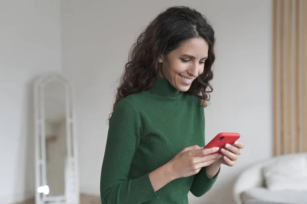 Joven mujer española feliz usando el teléfono móvil y charlando con amigos, mensajes de texto SMS en el teléfono inteligente — Foto de Stock