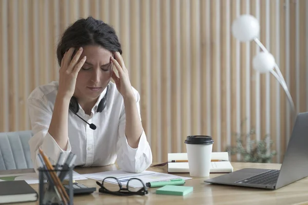 Donna d'affari spagnola stanca con gli occhi chiusi seduta sul posto di lavoro in ufficio, affetta da mal di testa — Foto Stock