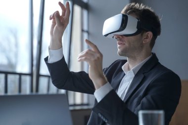 Heyecanlı ofis çalışanı VR gözlük takıyor dijital dünyada elle nesnelere dokunuyor.