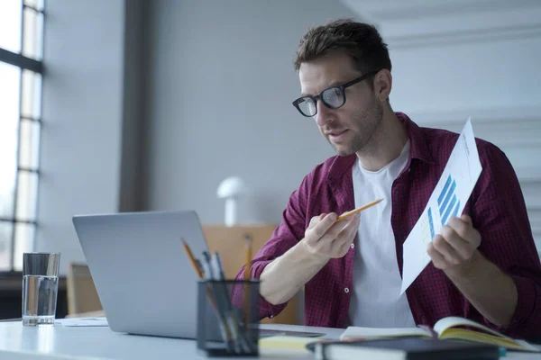 Jeune homme européen employé de bureau dans des lunettes montrant le rapport statistique lors d'une réunion en ligne — Photo