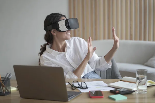 Mujer feliz explorando mundo aumentado en el trabajo, tocando 3D objetos virtuales con las manos — Foto de Stock