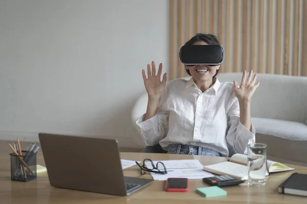 Emocionada empresaria con gafas de realidad virtual mientras trabaja en la oficina — Foto de Stock