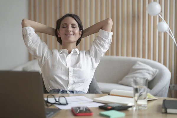 Freelancer dama sentada delante de la computadora portátil en posición relajada, los ojos cerrados y las manos detrás de la cabeza —  Fotos de Stock