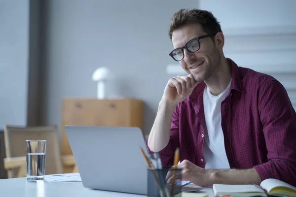 Giovane bello sorridente tedesco uomo ufficio lavoratore in occhiali godendo videochiamata sul computer portatile — Foto Stock