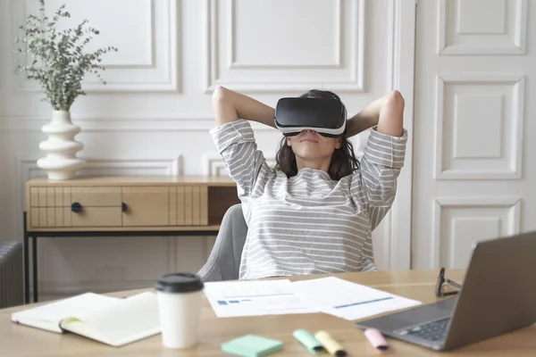Joven mujer feliz oficinista en gafas de realidad virtual en el lugar de trabajo, relajarse en casco VR en el trabajo — Foto de Stock
