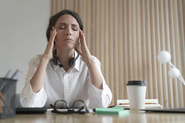 Frustrated Italian woman with closed eyes massaging temples, suffering from headache at work — Foto Stock