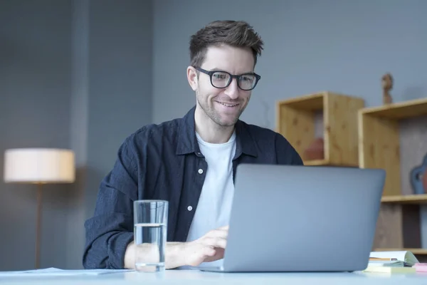 Jeune homme d'affaires souriant consultant financier européen travaillant à distance en ligne depuis son bureau à domicile — Photo