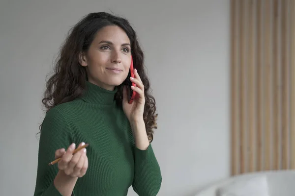 Atractiva joven empresaria española disfrutando de conversación telefónica, usando smartphone en el trabajo —  Fotos de Stock
