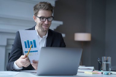 Resmi giyimde kendine güvenen genç erkek şirket CEO 'su online hissedar uzak toplantısı düzenliyor.