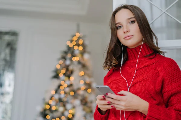 여자는 메이크업 대형된 스웨터를 이어폰 오디오 크리스마스 장식의 — 스톡 사진