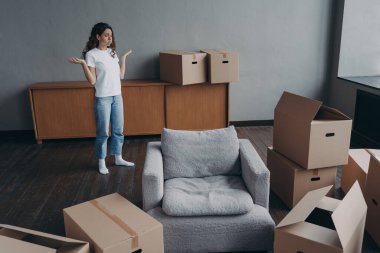 Spanish woman feels hard to move alone. Young lady is exhausted with boxes packing. Pretty girl in new apartment. Annoyed young lady has problem. Delivery service ordering concept.
