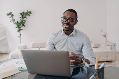 African american businessperson adviser or lawyer talking with client, distance working online at laptop. Professional marketing manager communicating with customers by video conference at home office