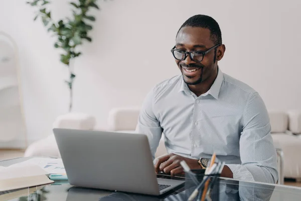 Улыбающийся Африканский Американский Бизнесмен Очках Работающий Ноутбуком Заключает Успешную Сделку — стоковое фото