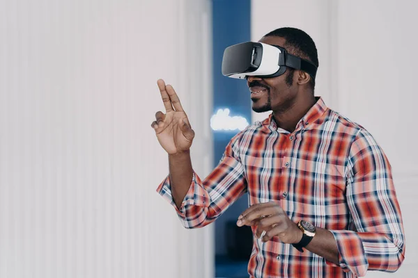 African american guy wearing virtual reality glasses, enjoying leisure free time in cyberspace. Modern black man playing video game simulation, testing purchase in online store. E commerce, tech