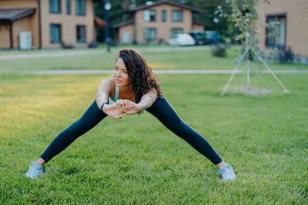 Femme Sportive Confiante Démontre Flexibilité Étend Extérieur Fait Des Exercices — Photo