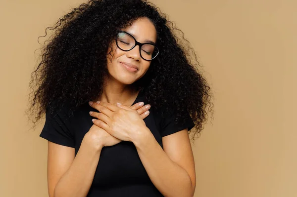 Rörde Härlig Hona Med Afro Frisyr Håller Båda Handflator Bröstet — Stockfoto
