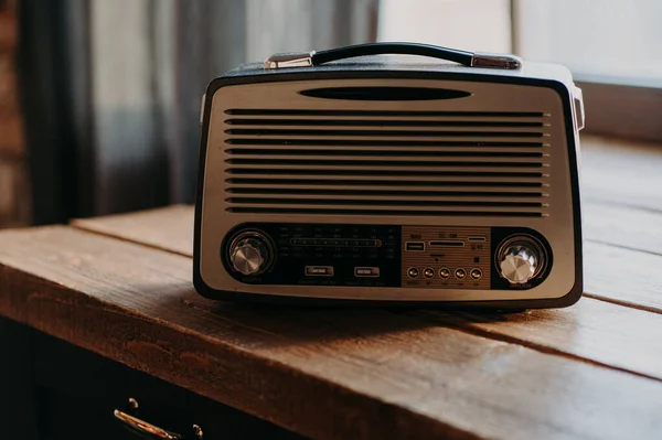 无线电广播音乐 旧收音机在木制桌子上的灯室里 古色古香过去和未来之间的音乐桥梁 正宗的复古风格 — 图库照片