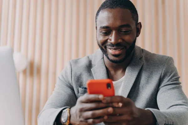 Veselý Mladý Afro Američan Stylovém Obleku Chatuje Online Smartphonu Dívá — Stock fotografie
