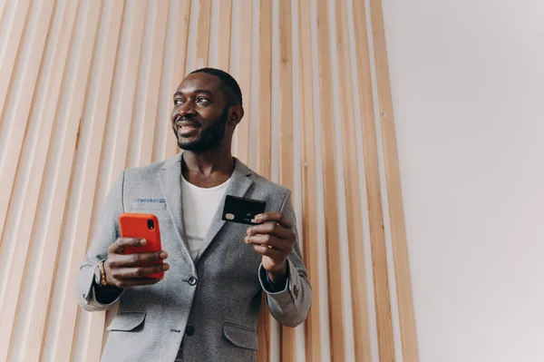 Nadšený Africko Americký Podnikatel Stylovém Blejzru Používající Smartphone Kreditní Kartu — Stock fotografie