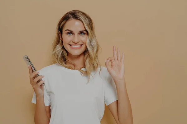 Mulher Alegre Feliz Camisa Casual Segurando Smartphone Mostrando Gesto Sendo — Fotografia de Stock