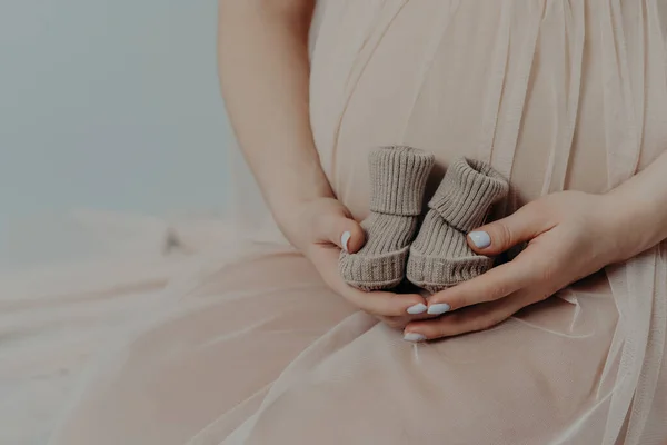 Koncepcja Macierzyństwa Ciąży Nierozpoznawalna Kobieta Ciąży Trzyma Małe Buty Brzuchu — Zdjęcie stockowe