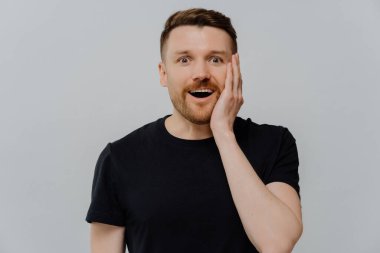 Bunun doğru olduğuna inanamıyorum. Siyah tişörtlü genç yakışıklı adam heyecandan çenesini indiriyor. Gri duvara karşı dururken inanılmaz bir şeyle şoke oluyor.