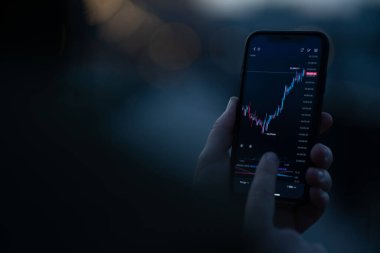 Çevrimiçi yatırım. Akıllı telefondan hisse senedi verilerini takip etmek için yatırım uygulamasını kullanarak gerçek zamanlı fiyat aktivitelerini analiz etmek. Ekranda mali tablosu olan cep telefonuna seçici odaklan