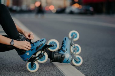 Tanınmayan kadın bacakları paten giyer açık havada egzersiz yapar sokak yollarında paten yapmaya hazırlanır. Yüzsüz patenci tehlikeli sporlara gider.