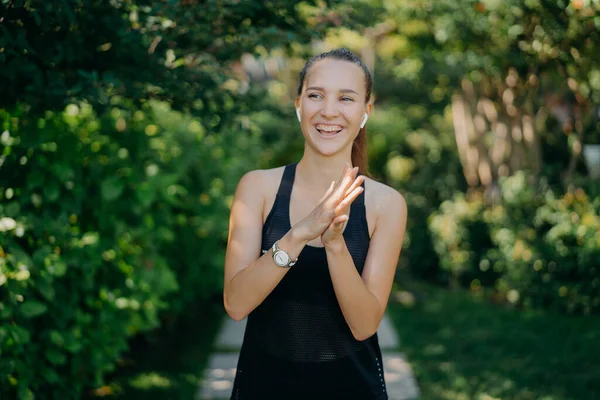 Overjoyed Dark Haired Woman Keeps Hands Together Laughs Happily Being — Fotografia de Stock