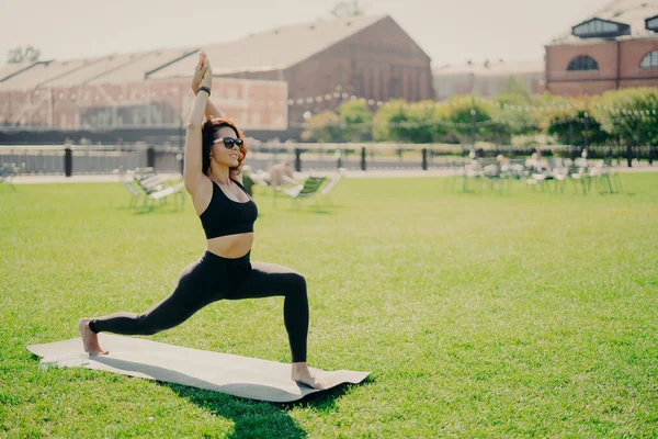 Concentrated Positive Woman Raises Arms Does Pilates Exercises Dressed Active — Stock Photo, Image