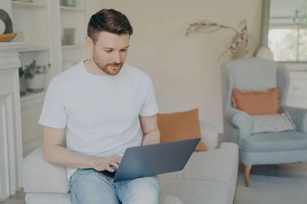 Jovem Sério Usando Computador Portátil Para Trabalho Remoto Casa Cara Imagens De Bancos De Imagens Sem Royalties