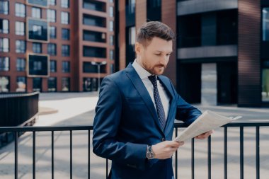 Şık giyinmiş gururlu CEO sabahın erken saatlerinde ofis merkezinde finans haberleri arayan başarılı bir girişimci olarak iş dünyasında yürürken şık giyiniyor.