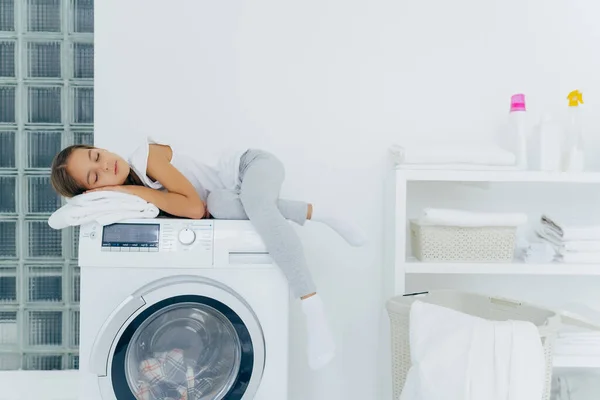 Tiro Horizontal Menina Tem Descanso Máquina Lavar Roupa Sente Cansado — Fotografia de Stock