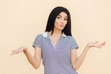 Güzel erkek clueless ifadesi olan, omuz silkiyor, dudaklar yuvarlak tutar, kararsız görünüyor bir yana, içinde rahat kıyafetler giymiş, stüdyo arka plan üzerinde izole. İnsanlar ve belirsizlik kavramı