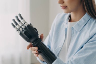 Güzel engelli kız biyonik protez koluna dokunuyor, yakın çekim. Robot elli bir kadın yapay uzvun bileğine dokunuyor. Engelliler için tıbbi yüksek teknoloji konsepti.